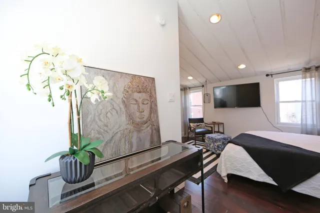 a bedroom with a bed and wooden floor