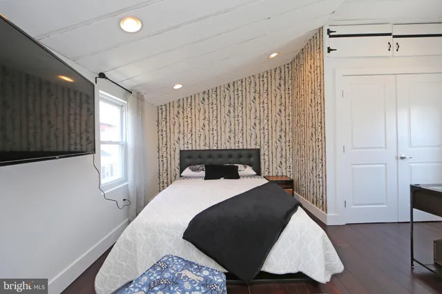 a bedroom with a bed and a flat screen tv