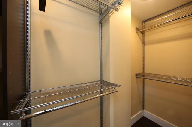 a view of walk in closet with empty racks