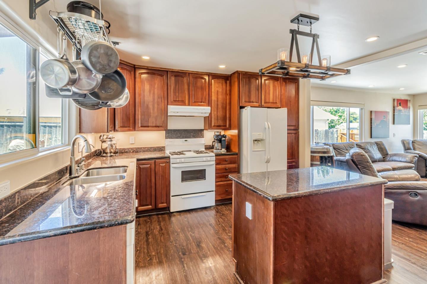 321 Vineyard Drive San Jose, CA 95119 - Photo 4 of 29 a kitchen with kitchen island granite countertop a stove a sink dishwasher and white cabinets with wooden floor