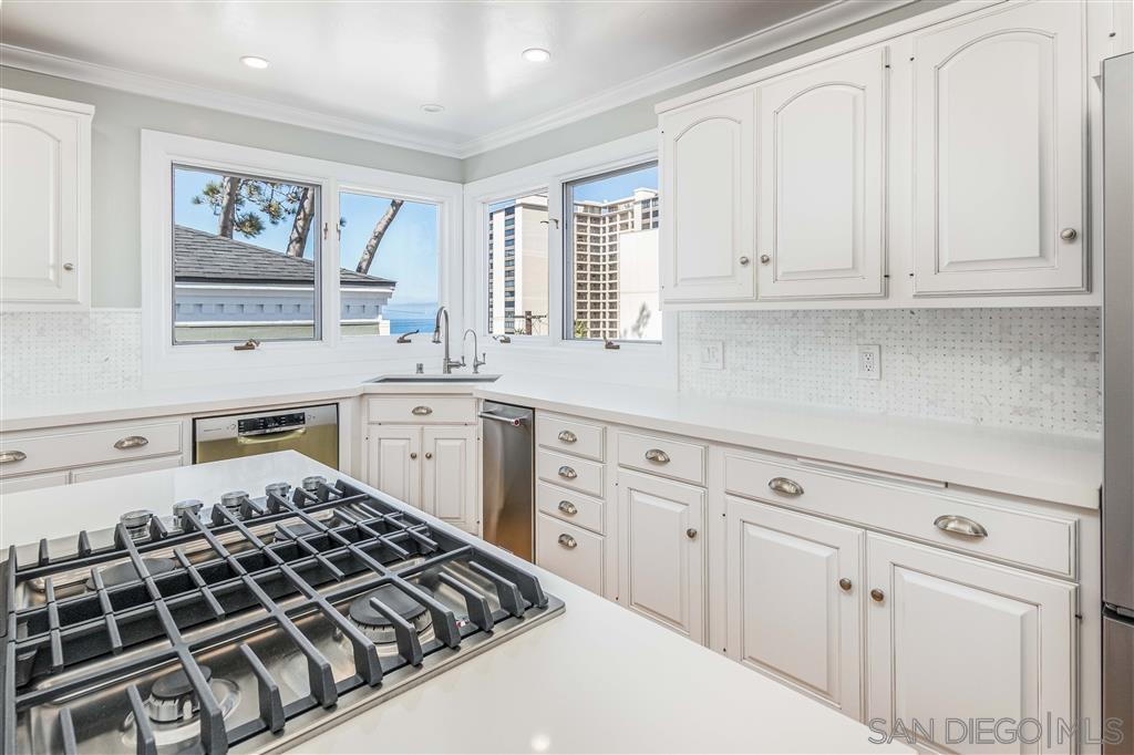 862 Prospect Street, Unit 1 La Jolla, CA 92037 - Photo 10 of 25 a kitchen with white cabinets and a stove top oven