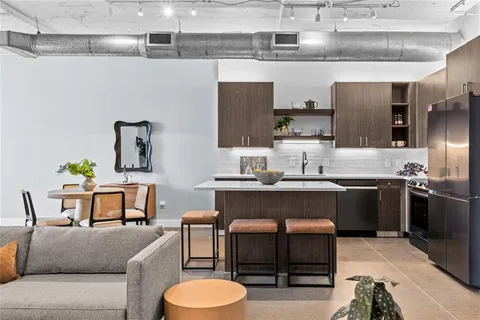 a living room with furniture a sink and kitchen view