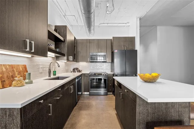 a kitchen with stainless steel appliances a sink stove and refrigerator