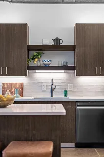 a kitchen with a sink and a stove with wooden floor