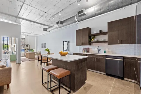 a kitchen with a sink stainless steel appliances and view living room