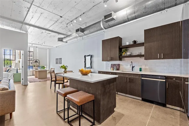 a kitchen with a sink stainless steel appliances and view living room