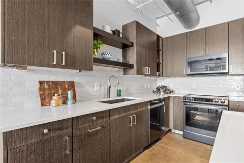a kitchen with stainless steel appliances a sink stove and cabinets