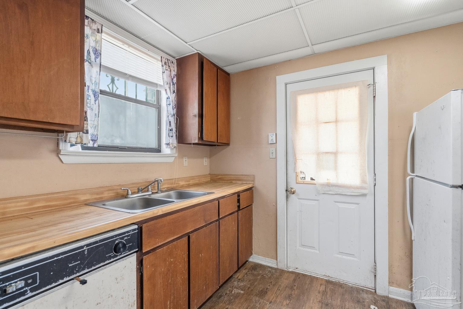 1920 North Spring Street Pensacola, FL 32501 - Photo 17 of 43 a kitchen with a sink a refrigerator and cabinets