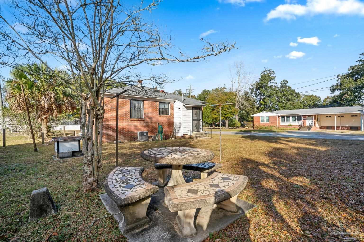 1920 North Spring Street Pensacola, FL 32501 - Photo 2 of 43 a view of a patio with couches table and chairs under an umbrella with large trees