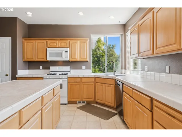 a kitchen with stainless steel appliances granite countertop a sink stove and cabinets
