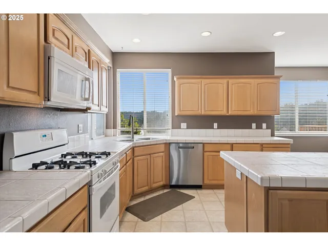 a kitchen with stainless steel appliances granite countertop a sink stove and cabinets