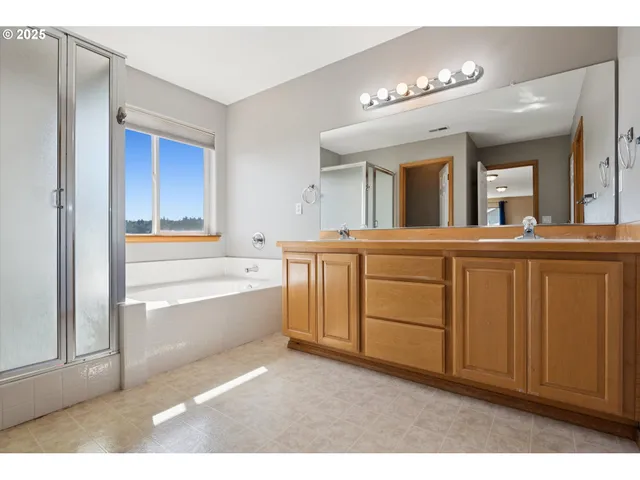 a bathroom with a tub sink and mirror