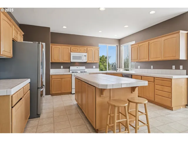 a kitchen with kitchen island a sink table and chairs