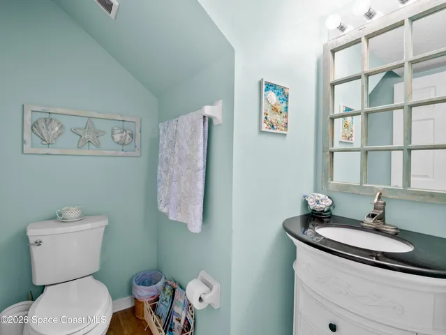 a bathroom with a granite countertop toilet sink and mirror