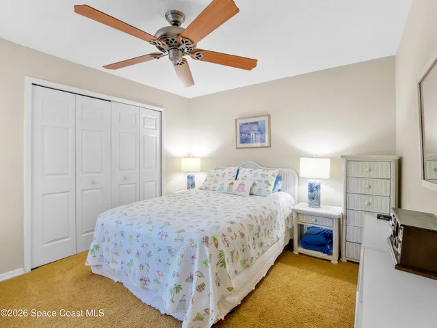 a bedroom with a bed and a ceiling fan