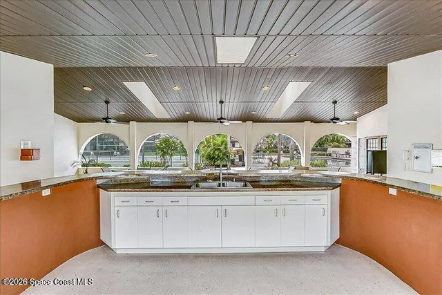a kitchen with granite countertop a sink and wooden cabinets
