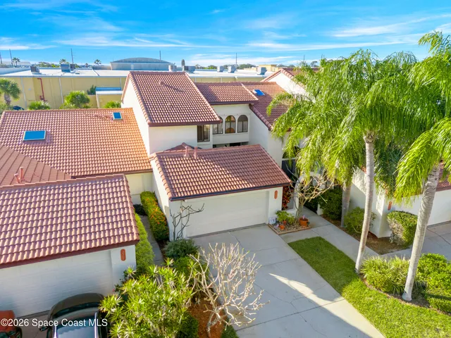 a front view of a house with a yard and potted plants