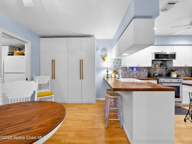 a room with stainless steel appliances kitchen island granite countertop a sink a stove and a refrigerator