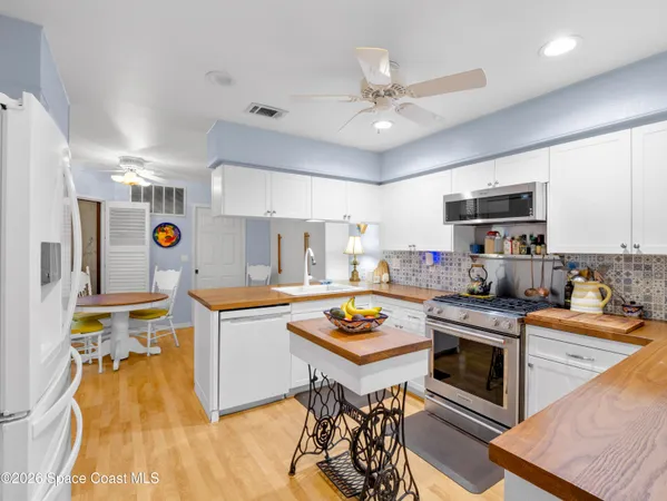 a kitchen with a stove a refrigerator and a dining table