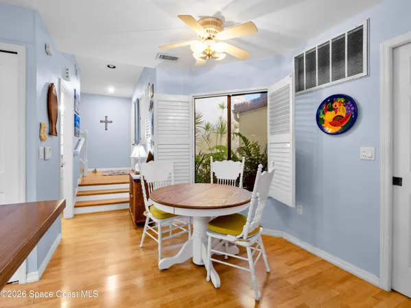 a view of a dining room with furniture and a chandelier fan