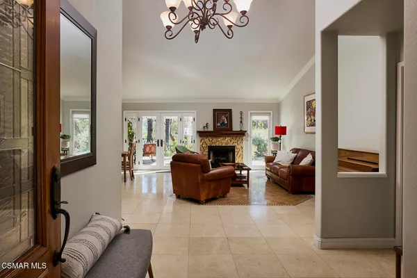 a view of a dining room with furniture large window a livingroom and chandelier