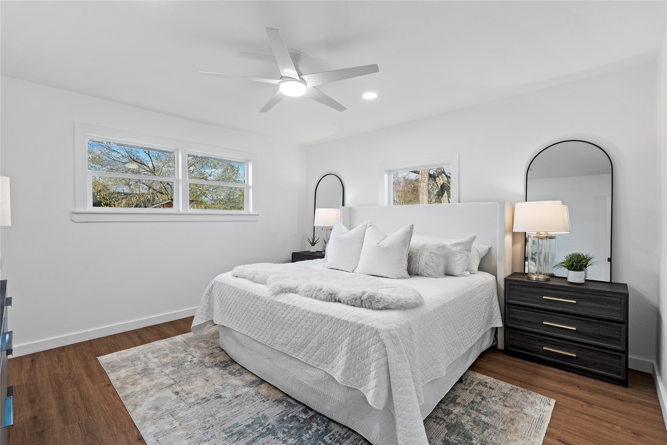 5023 Redstart Street Houston, TX 77035 - Photo 23 of 34 This spacious and airy bedroom features wide-plank flooring, a contemporary ceiling fan, and multiple windows that frame peaceful views of the mature trees outside.