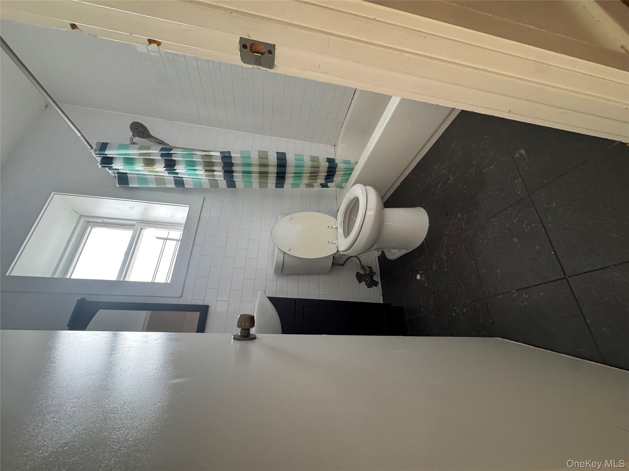 96-02 Northern Boulevard, Unit 3B Queens, NY 11368 - Photo 3 of 5 a bathroom with a toilet and a shower