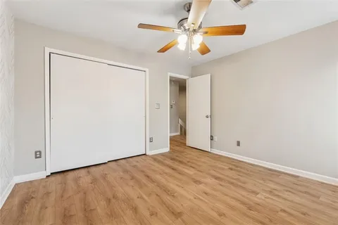 an empty room with a ceiling fan and a window