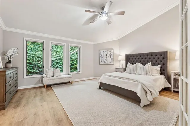 a spacious bedroom with a bed a couch and large window