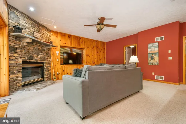 a living room with furniture a fireplace and a floor to ceiling window