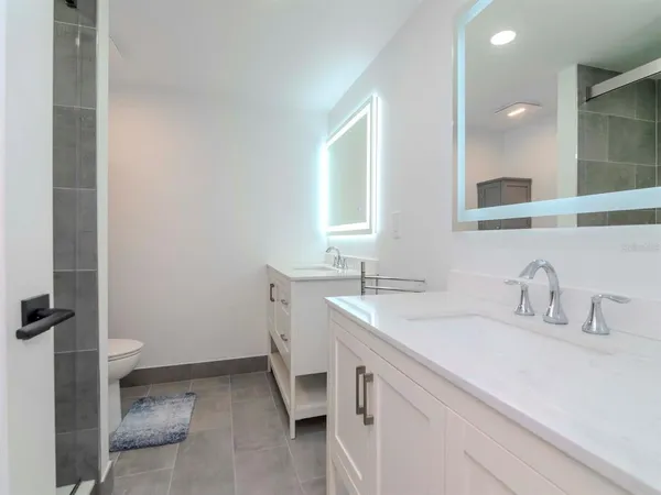 a bathroom with a sink a toilet and shower