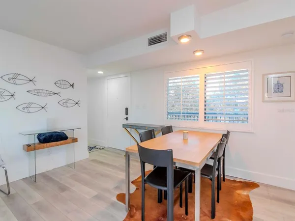 a kitchen with stainless steel appliances granite countertop a dining table chairs and granite counter tops
