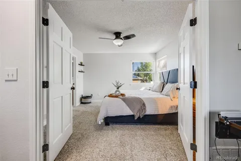 a bed room with a bed and a ceiling fan