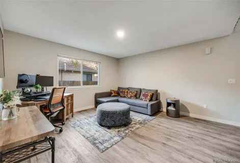 a living room with furniture a flat screen tv and a window