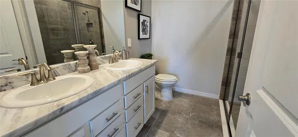 a bathroom with a double vanity sink toilet and a mirror