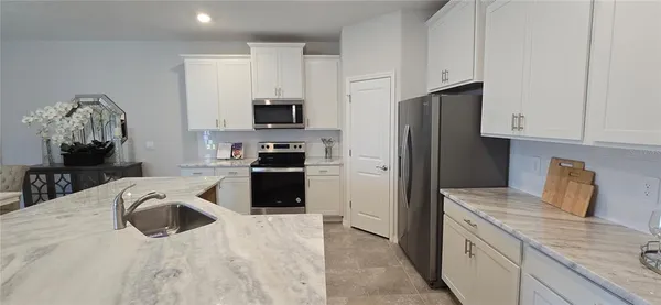 a kitchen with granite countertop a refrigerator stove and sink