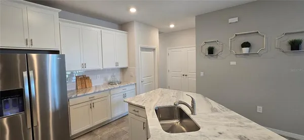 a kitchen with white cabinets and refrigerator