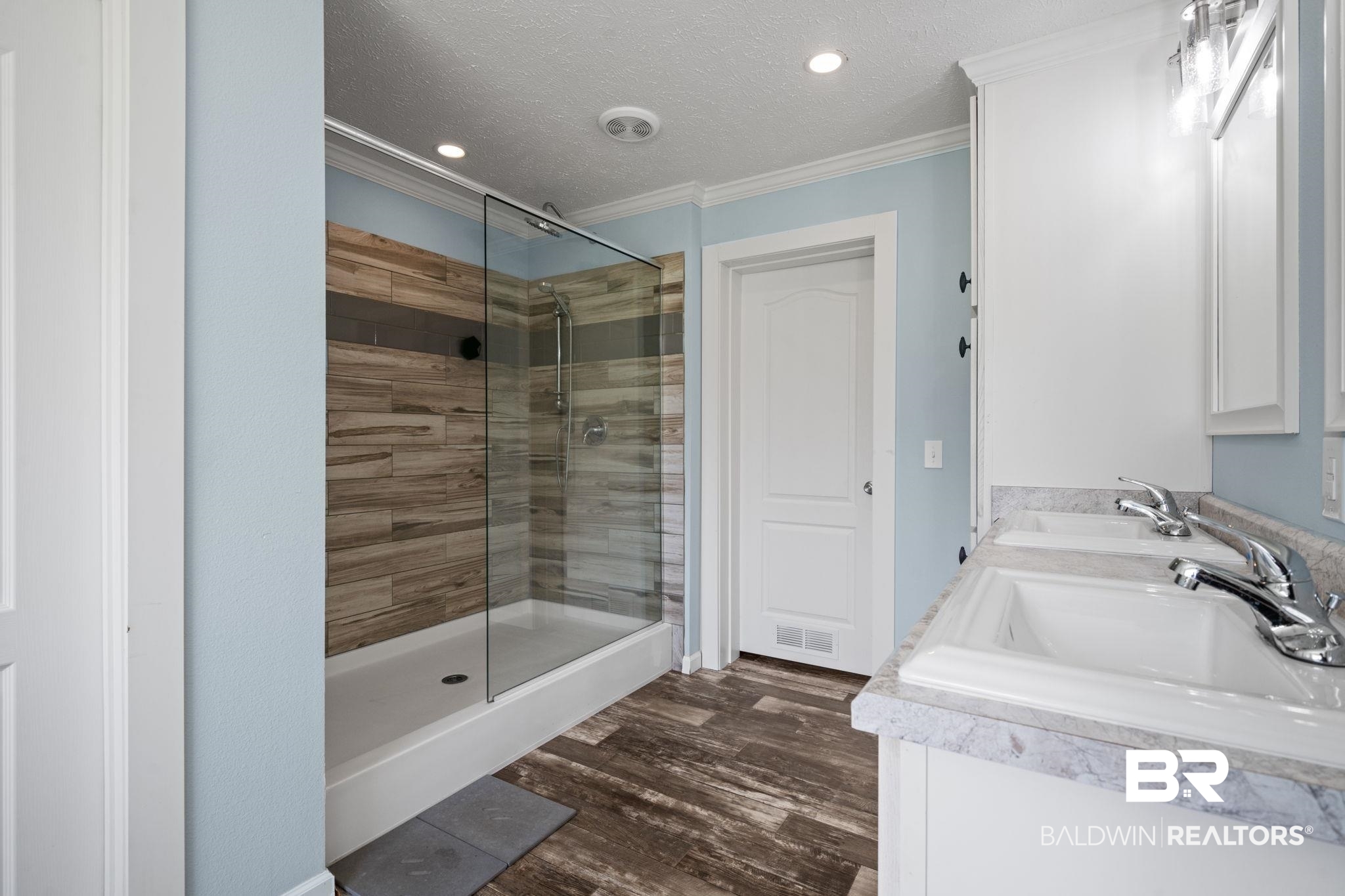 10703 South Ridge Drive Semmes, AL 36575 - Photo 24 of 37 Bathroom featuring ornamental molding, a shower stall, double vanity, a textured ceiling, and wood finished floors