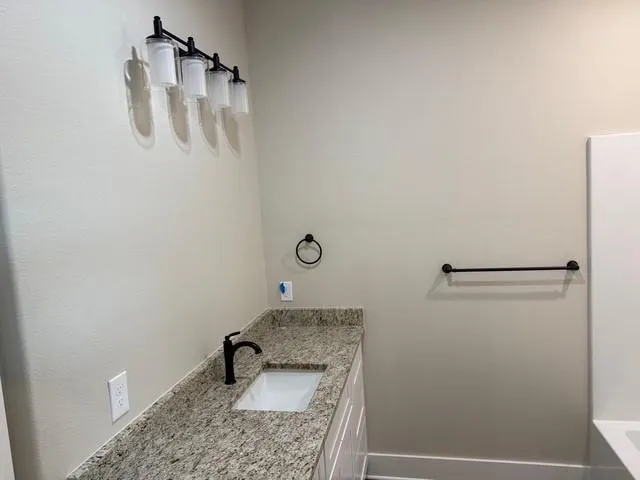 a bathroom with a granite countertop sink