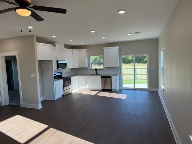 a view of kitchen with refrigerator stove and a window