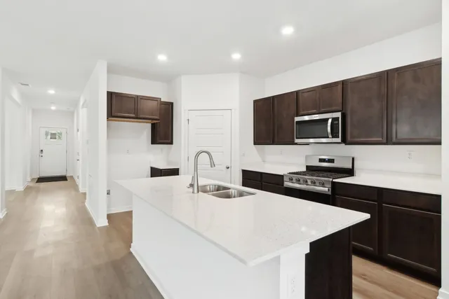 a kitchen with a sink a microwave and cabinets