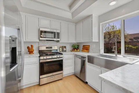 a kitchen with stainless steel appliances granite countertop a stove a sink and a refrigerator