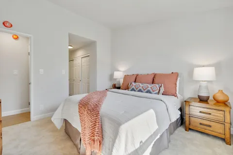 a bedroom with a bed and a lamp on the dresser