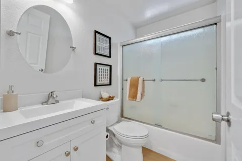 a bathroom with a sink mirror vanity and toilet
