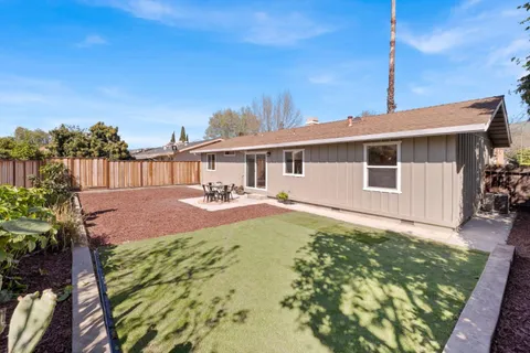 a view of a house with backyard and sitting area