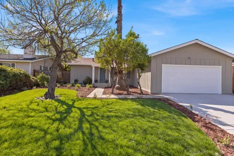 a view of a house with backyard sitting area and garden