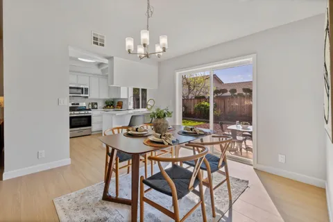 a view of a dining room with furniture a chandelier and wooden floor