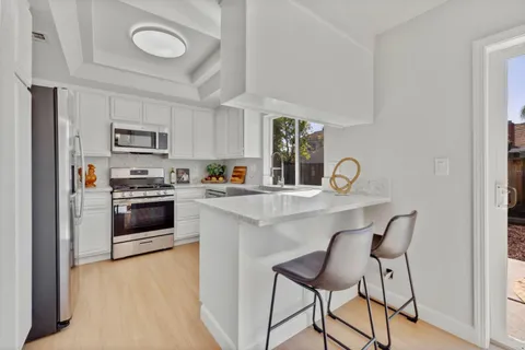 a kitchen with granite countertop a stove a sink and a refrigerator