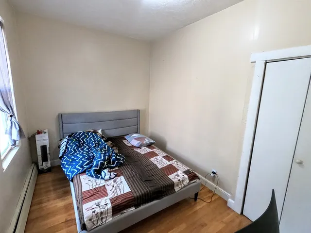a bed sitting in a bedroom next to a window