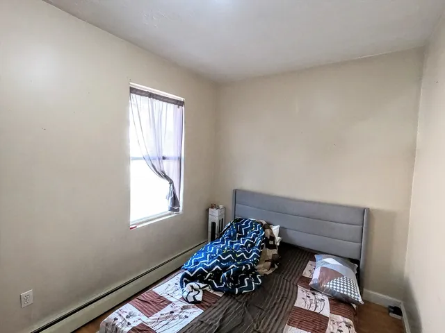 a bed sitting in a bedroom next to a window